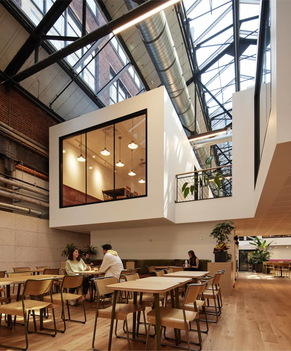 Un espace collaboratif moderne : Une salle de conférence au bureau de Workleap à Montréal, avec vue sur un café ensoleillé