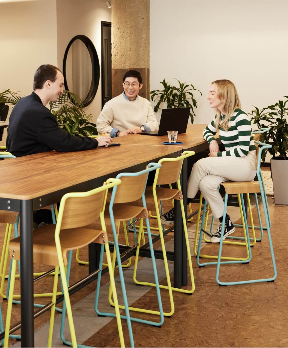 Three Workleap employees collaborating in a modern and casual setting, fostering teamwork and innovation